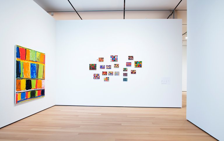 Abstract paintings in different sizes by Stanley Whitney featuring a structured grid of colorful rectangular blocks, separated by thin lines, creating a rhythmic composition shown here in an exhibition at Buffalo AKG Art Museum