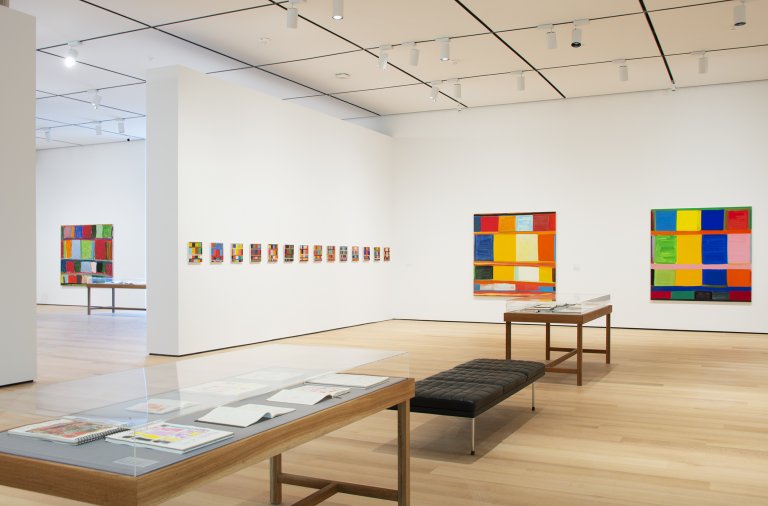 Abstract paintings by Stanley Whitney featuring a structured grid of colorful rectangular blocks, separated by thin lines, creating a rhythmic composition shown here in an exhibition at Buffalo AKG Art Museum